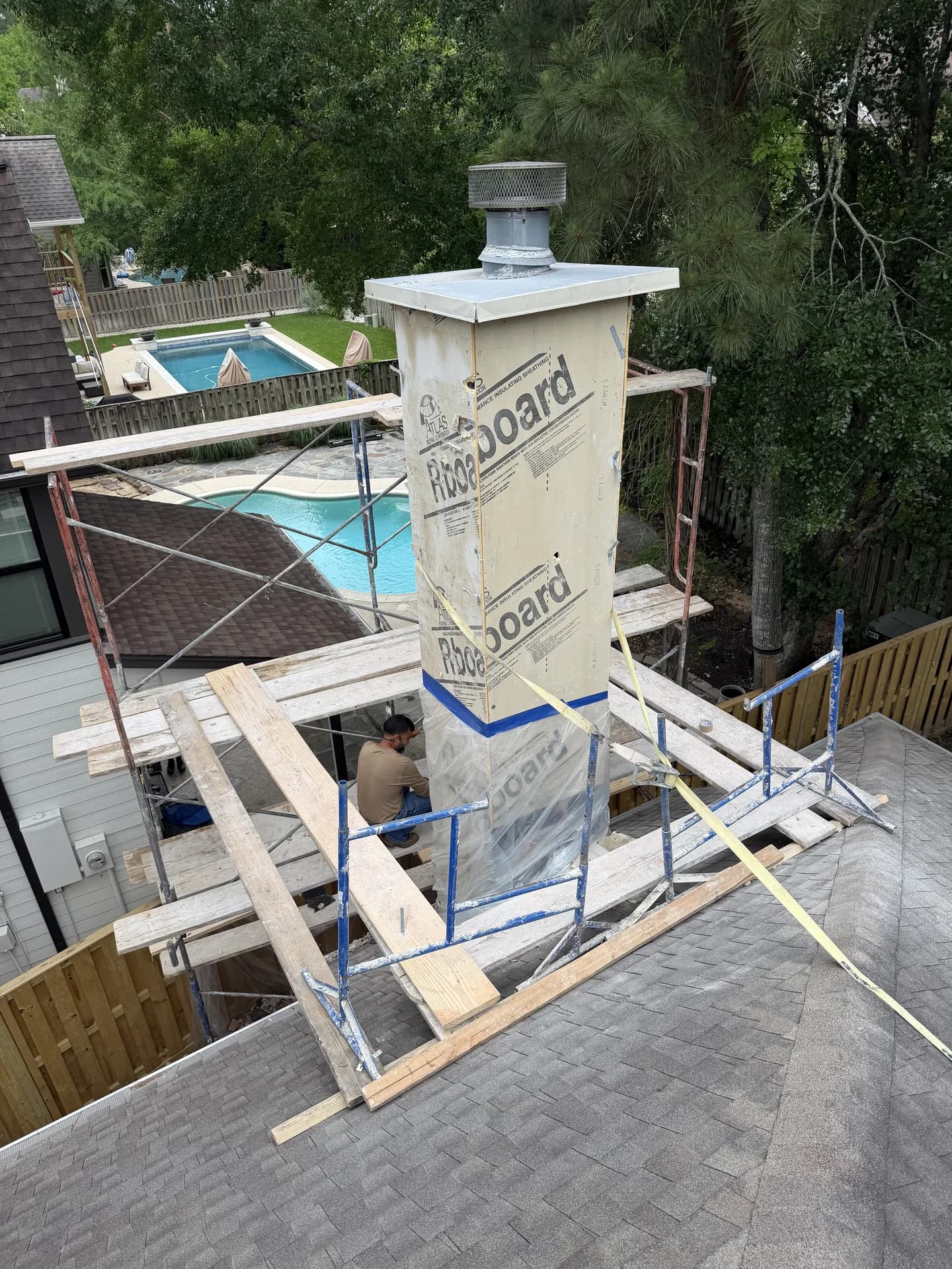 Close-up of a rebuilt chimney chase showing Atlas R-Board insulation board wrap and metal cap